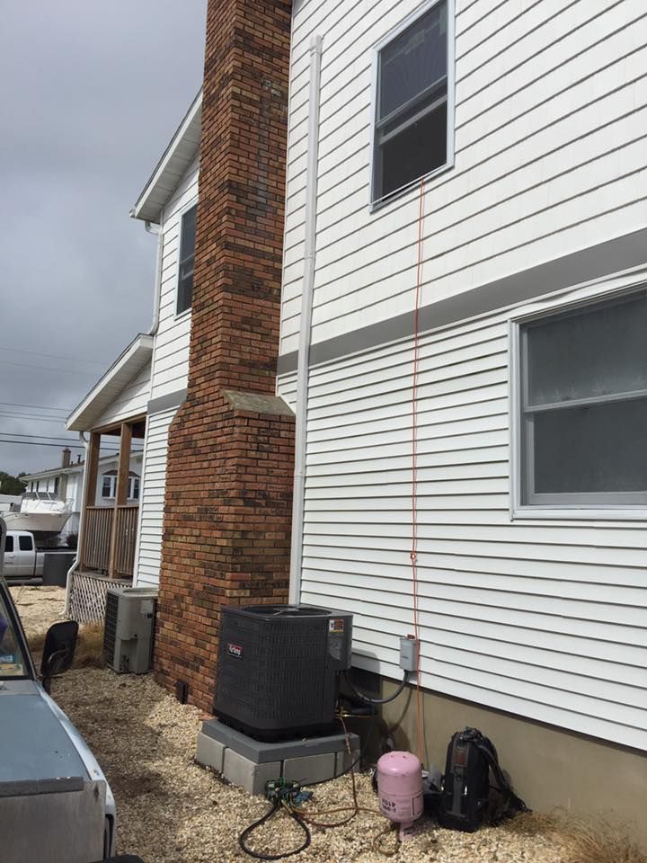 A white house with a brick chimney on the side of it.