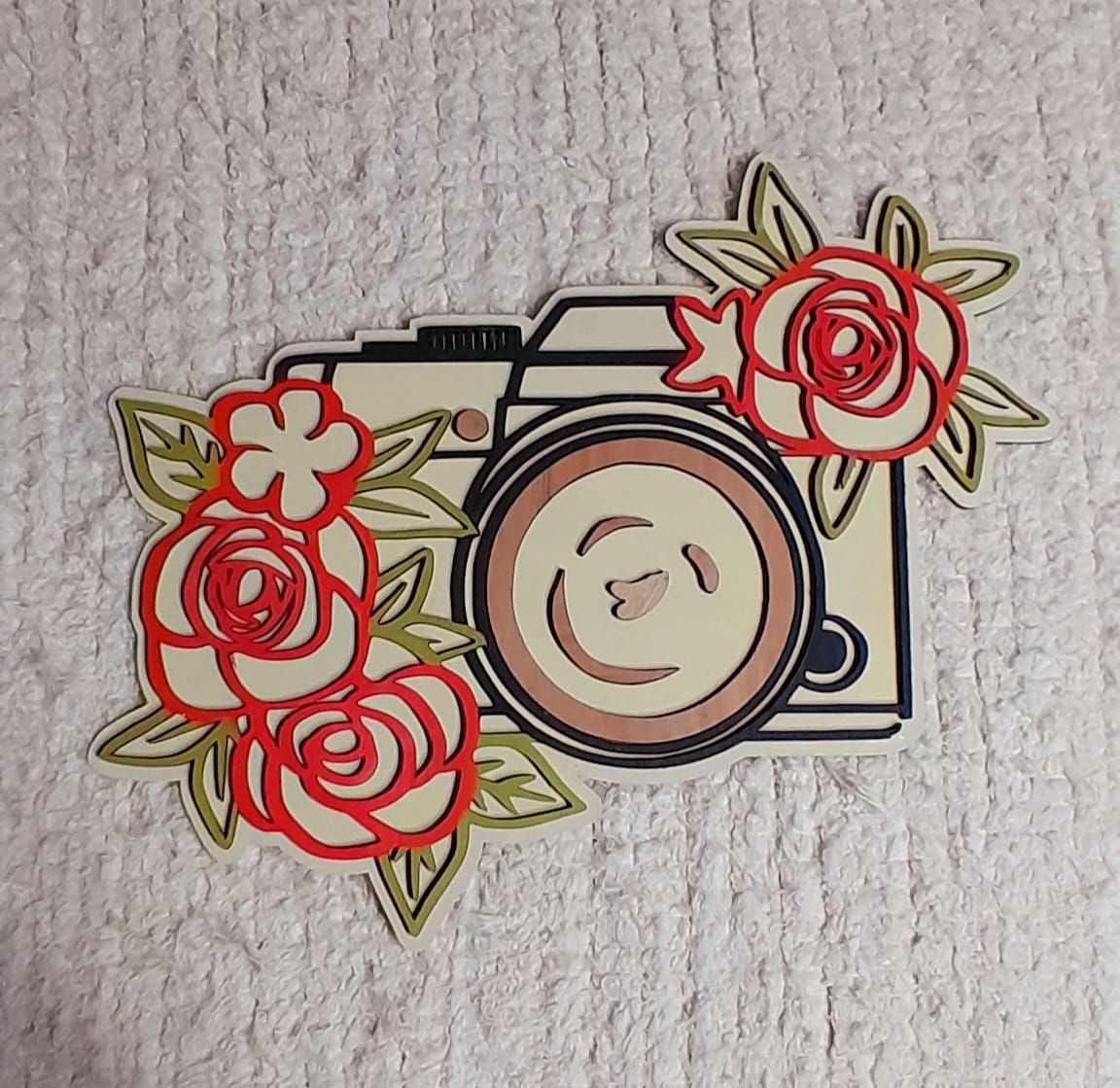 Una imagen de una cámara con rosas alrededor.