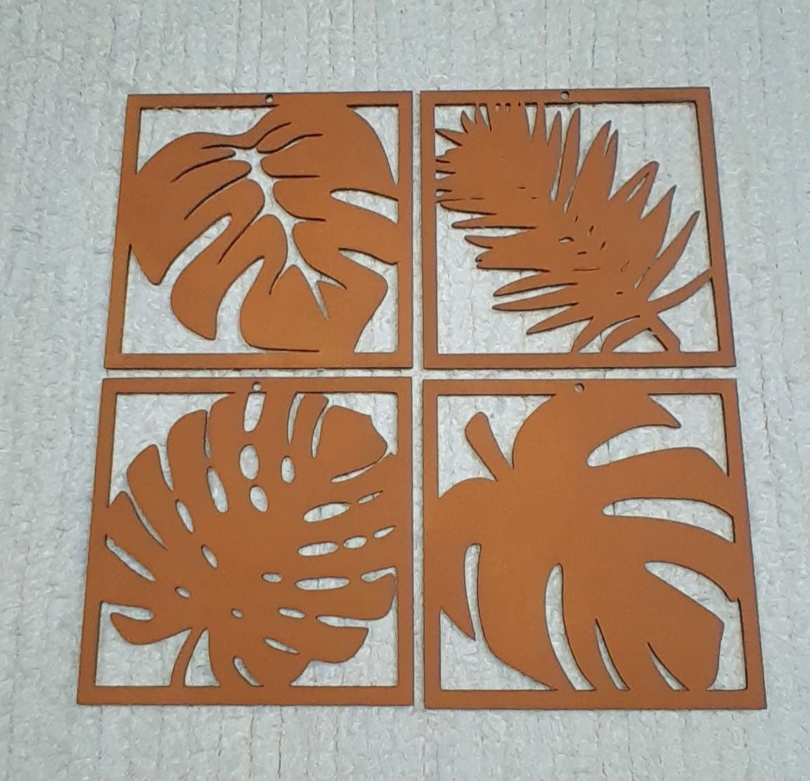 Cuatro cuadrados con hojas recortadas.