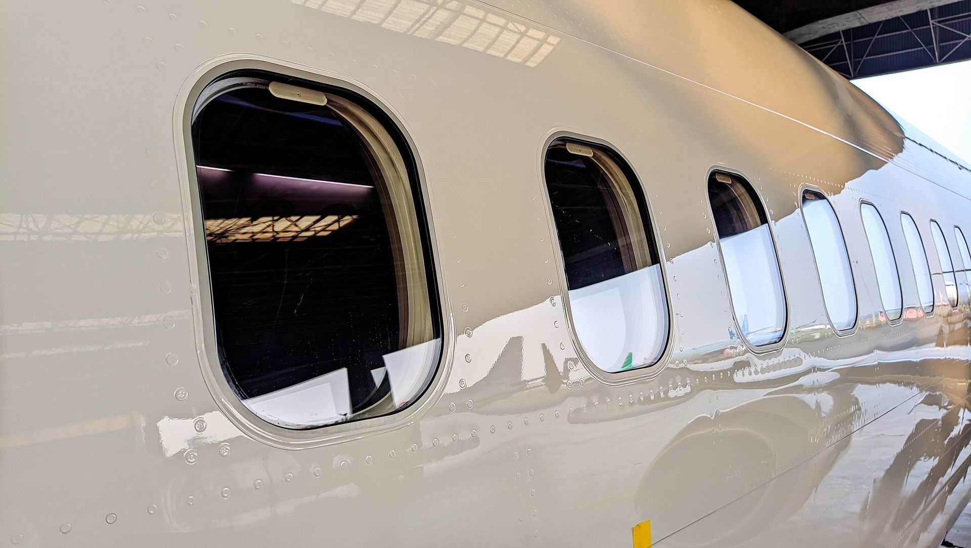 Close-up of airplane windows in a silver exterior.