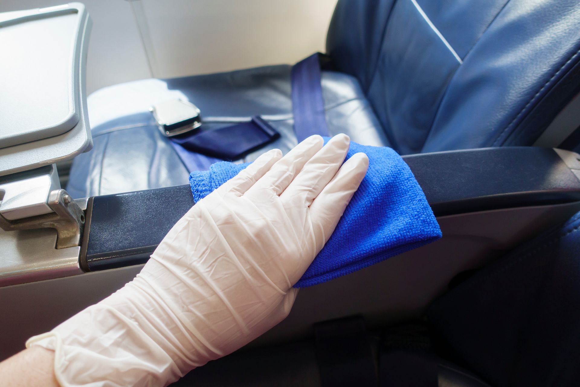 A person is cleaning a chair from an aircraft. A person is cleaning a chair from an aircraft.