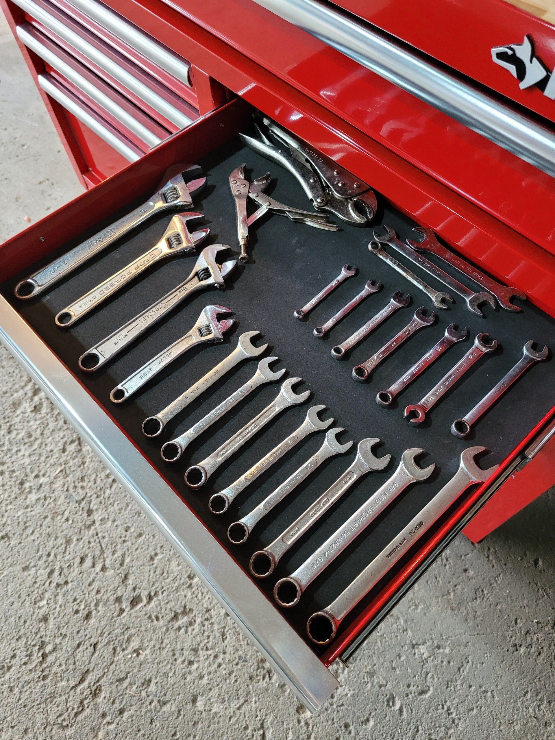 A drawer full of wrenches in a red toolbox