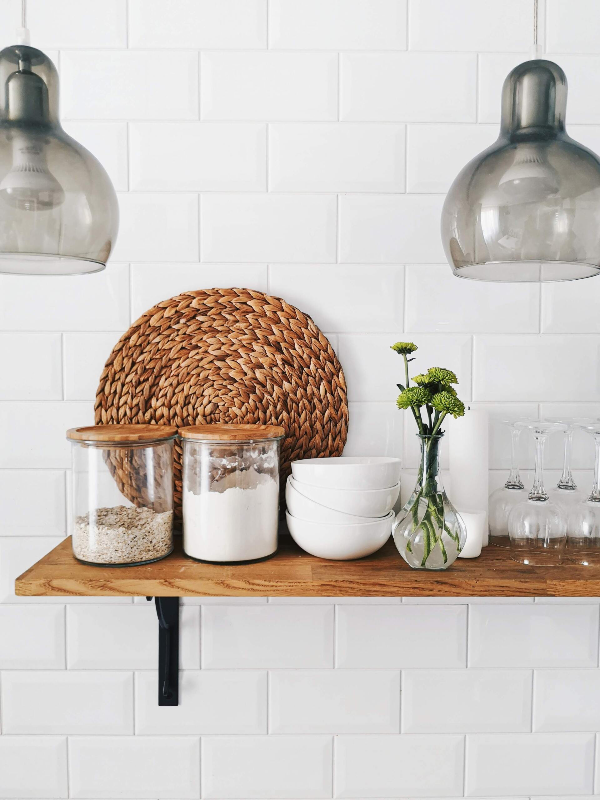 A wooden shelf with jars of food and bowls on it.