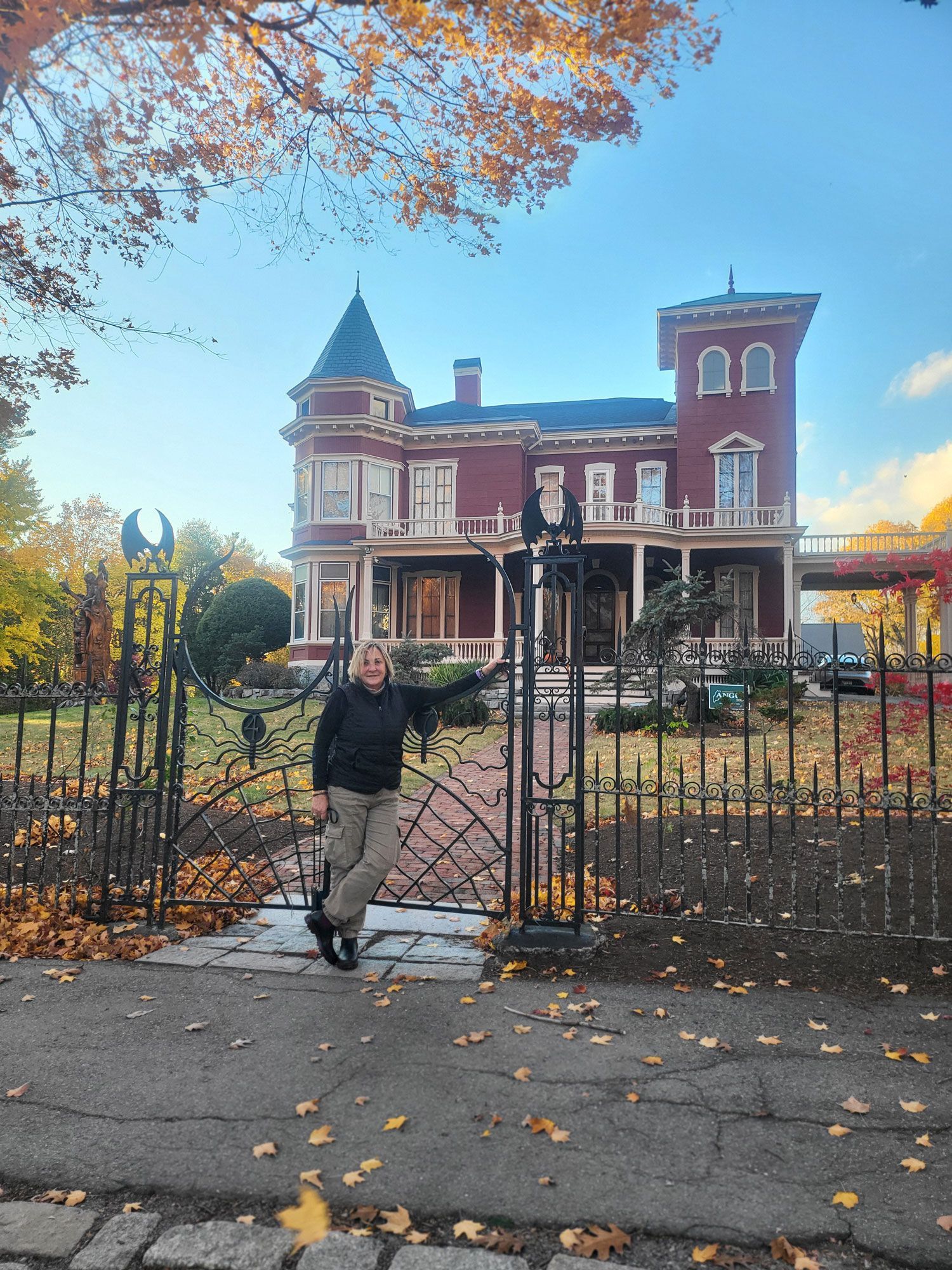 una donna è in piedi davanti a una grande casa rossa