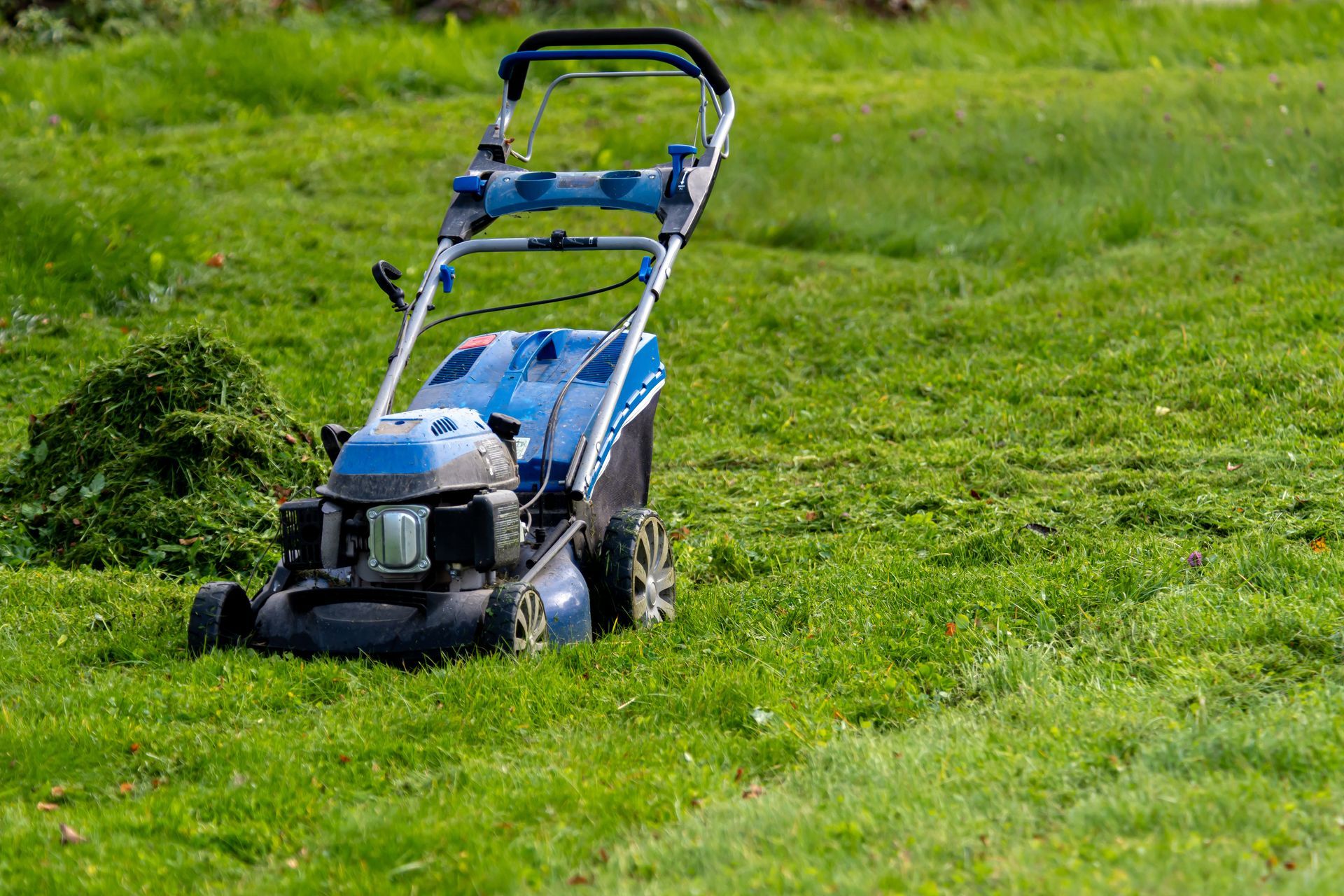 Laying red brick pavers in a zigzag pattern outdoors. Bricks are stacked; tools and a person are visible.