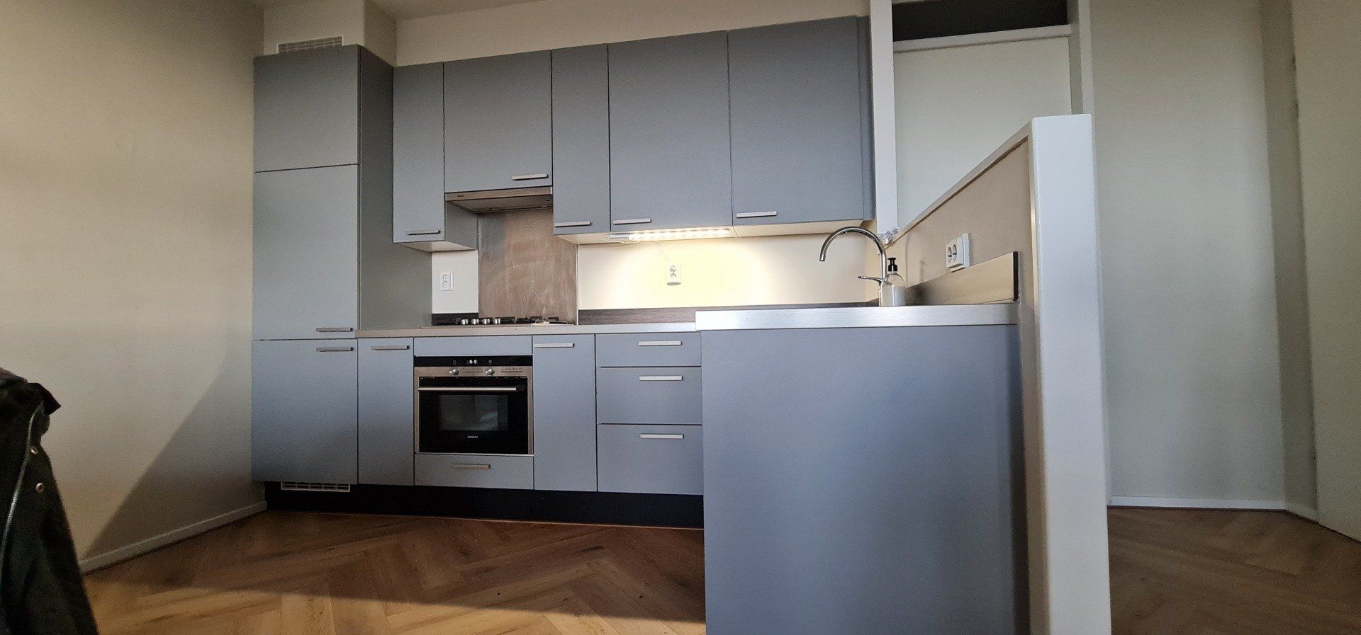 Een keuken met veel kasten en apparaten