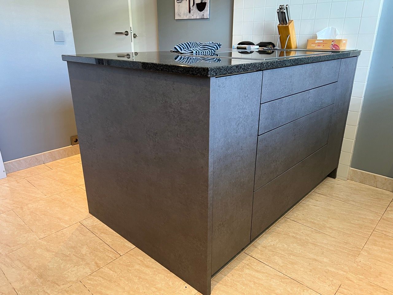 Een kookeiland met een zwart granieten aanrechtblad