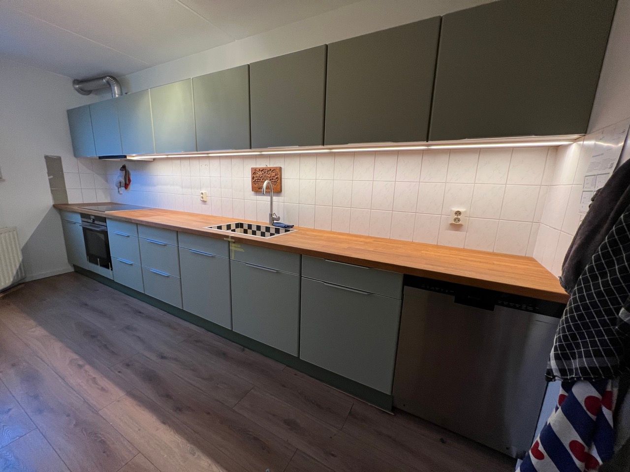 Een keuken met roestvrijstalen apparatuur en houten aanrechtbladen