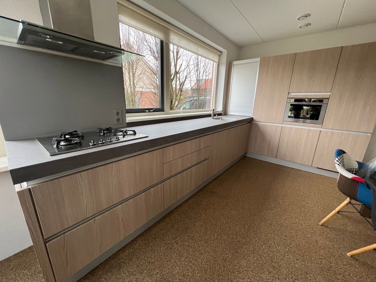 Een keuken met houten kasten en een kookplaat/oven.