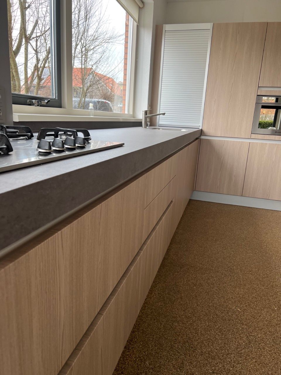 Een keuken met houten kasten en een kookplaat oven