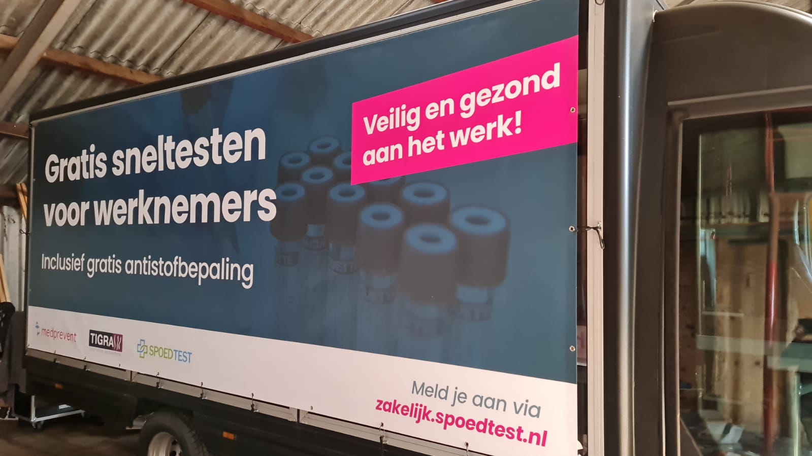 A truck with a large sign that says gratis sneltesten voor werknemers