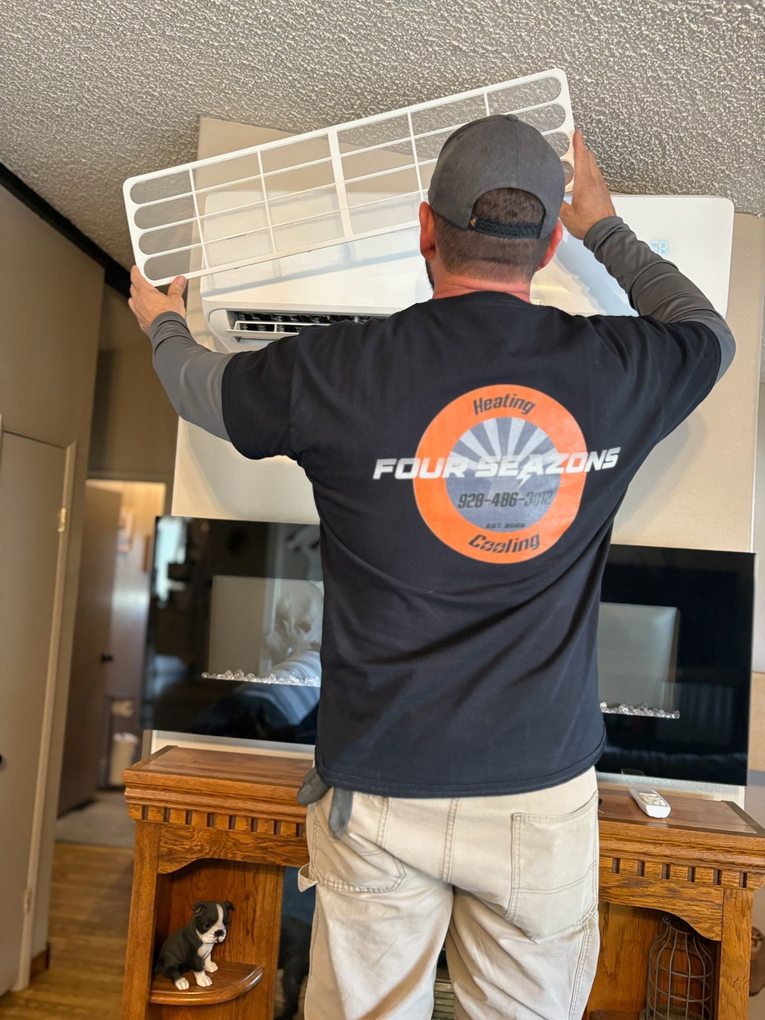 A man wearing a black shirt that says four seasons on it