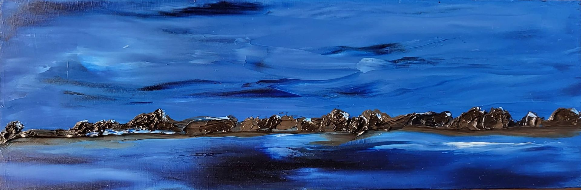 Artist’s Reflection
This miniature, painted with a knife on treated masonite, measures 9 by 3 inches. The format itself appeals to me—a horizontal stretch that feels at once expansive and intimate. It lends itself naturally to landscape, giving space for the eye to wander while still remaining grounded in something contained.
I created it as part of a practice I return to between major works. As I prepare for my next exhibition in 2026, I often step back from the intensity of the larger collection to redirect my energy and relax. These miniatures arise almost organically—usually from leftover paint—and in that way, they feel like gifts: small, unplanned, but deeply meditative.
The knife work here is instinctual. I enjoy the tactile quality of impasto, especially when used sparingly to suggest the texture of rocks or land masses without overwhelming the sky. I wanted the atmosphere to dominate—quiet, contemplative, even a little haunted by stillness. The opening in the sky felt necessary, like a breath being held and then slowly released.
Working primarily in blue—cobalt, ultramarine, perhaps a touch of cerulean, I tried to let the variations carry the emotional weight. The centre holds a faint warmth, grounding the scene and keeping it from becoming too cold or distant. There’s a tension here that I didn’t entirely plan, but welcomed: the pull between shadow and light, between solitude and serenity.
These small works, while unburdened by the conceptual weight of a full exhibition, often reveal something more honest. They’re pauses, reflections—moments when I allow myself to simply respond without overthinking
