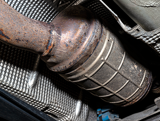 A close up of a rusty diesel particulate filter on a car