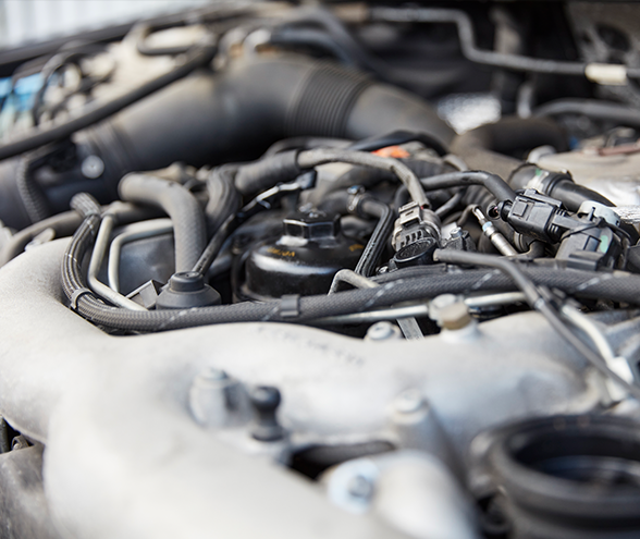 A close up of a car engine with a lot of wires coming out of it.