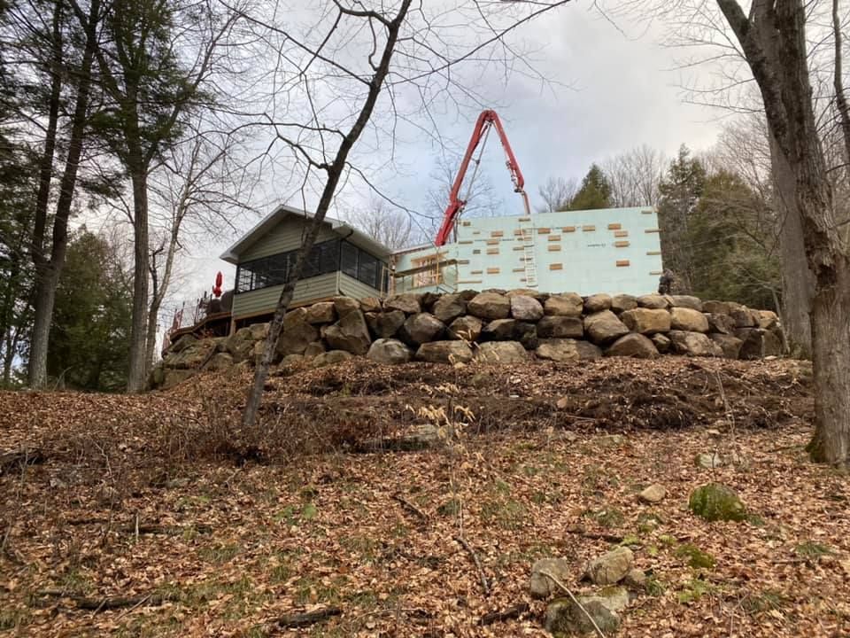 A house is being built on top of a hill in the woods.