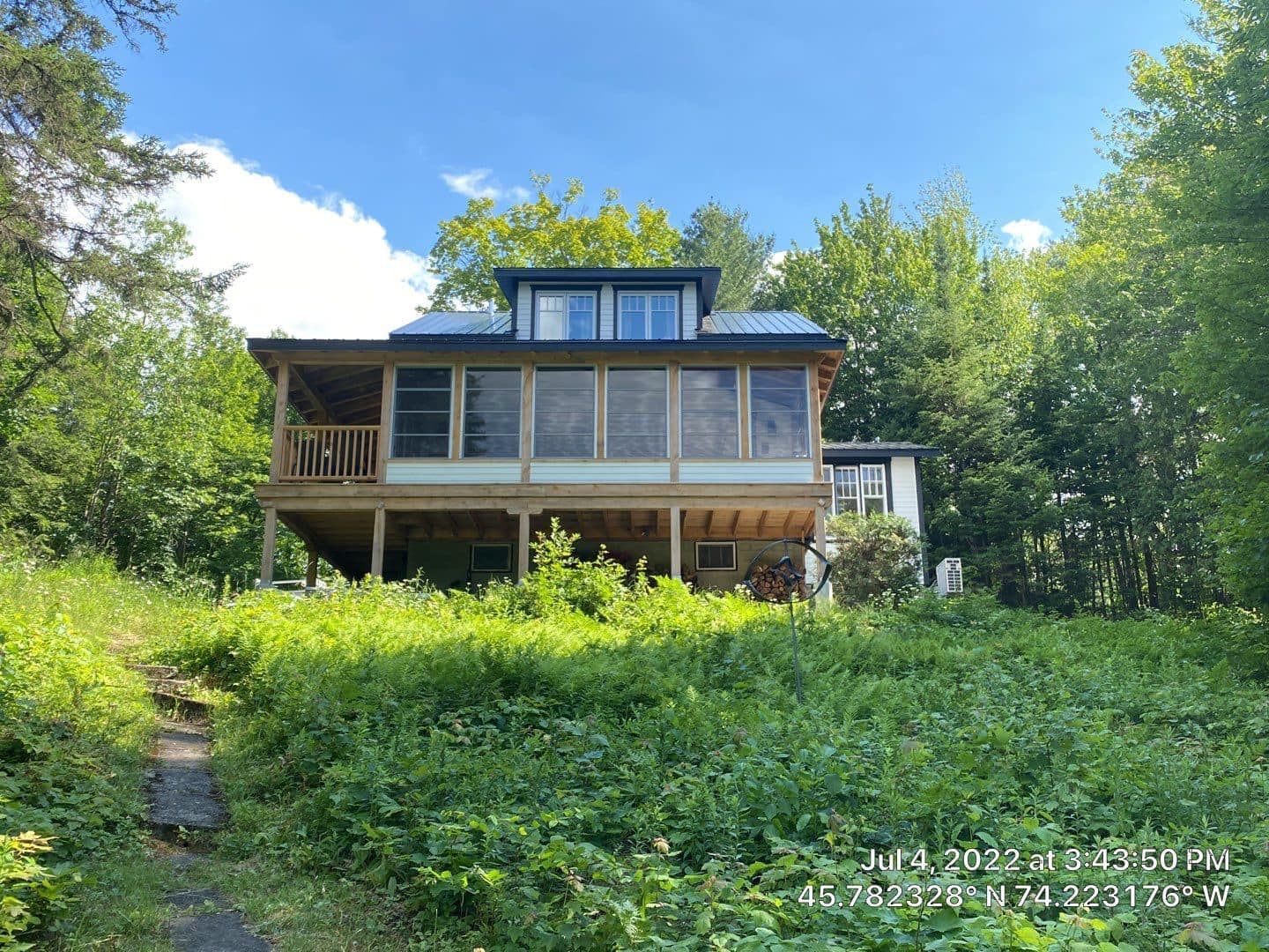 A large house with a lot of windows is surrounded by trees.