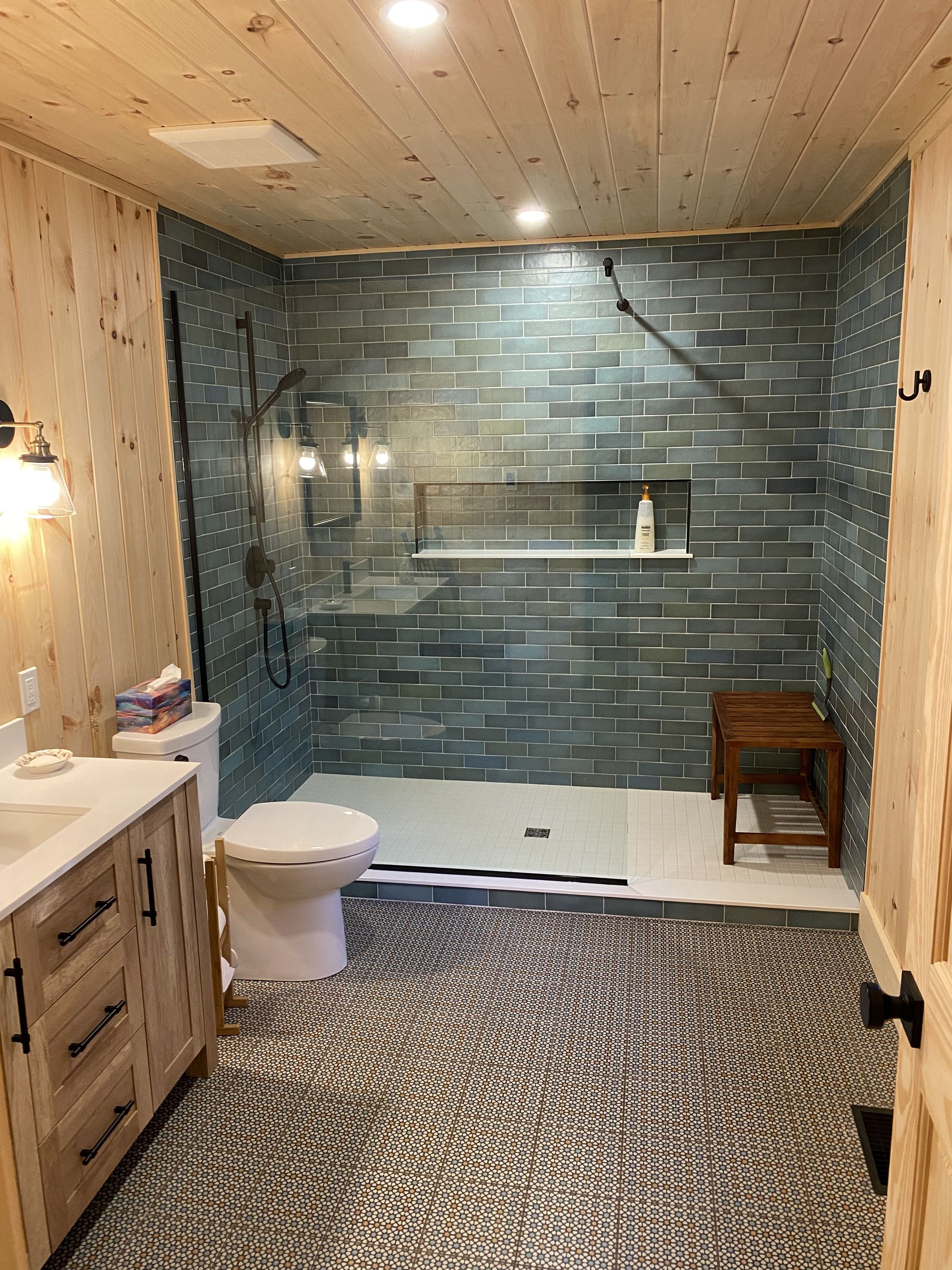 A bathroom with a toilet , sink , and walk in shower.