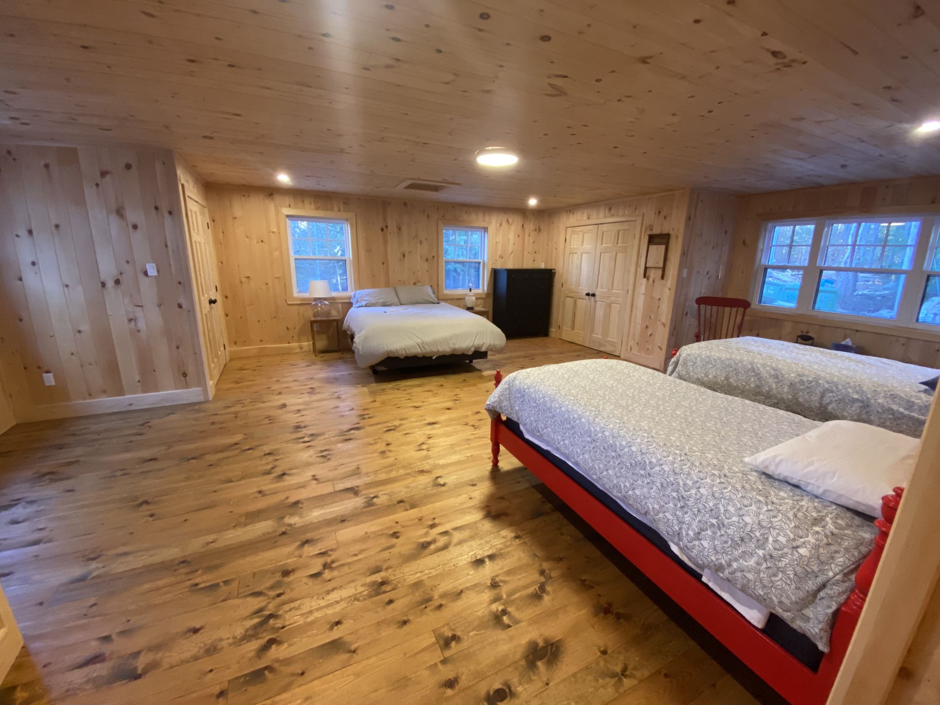 A bedroom with two beds and a wooden floor.