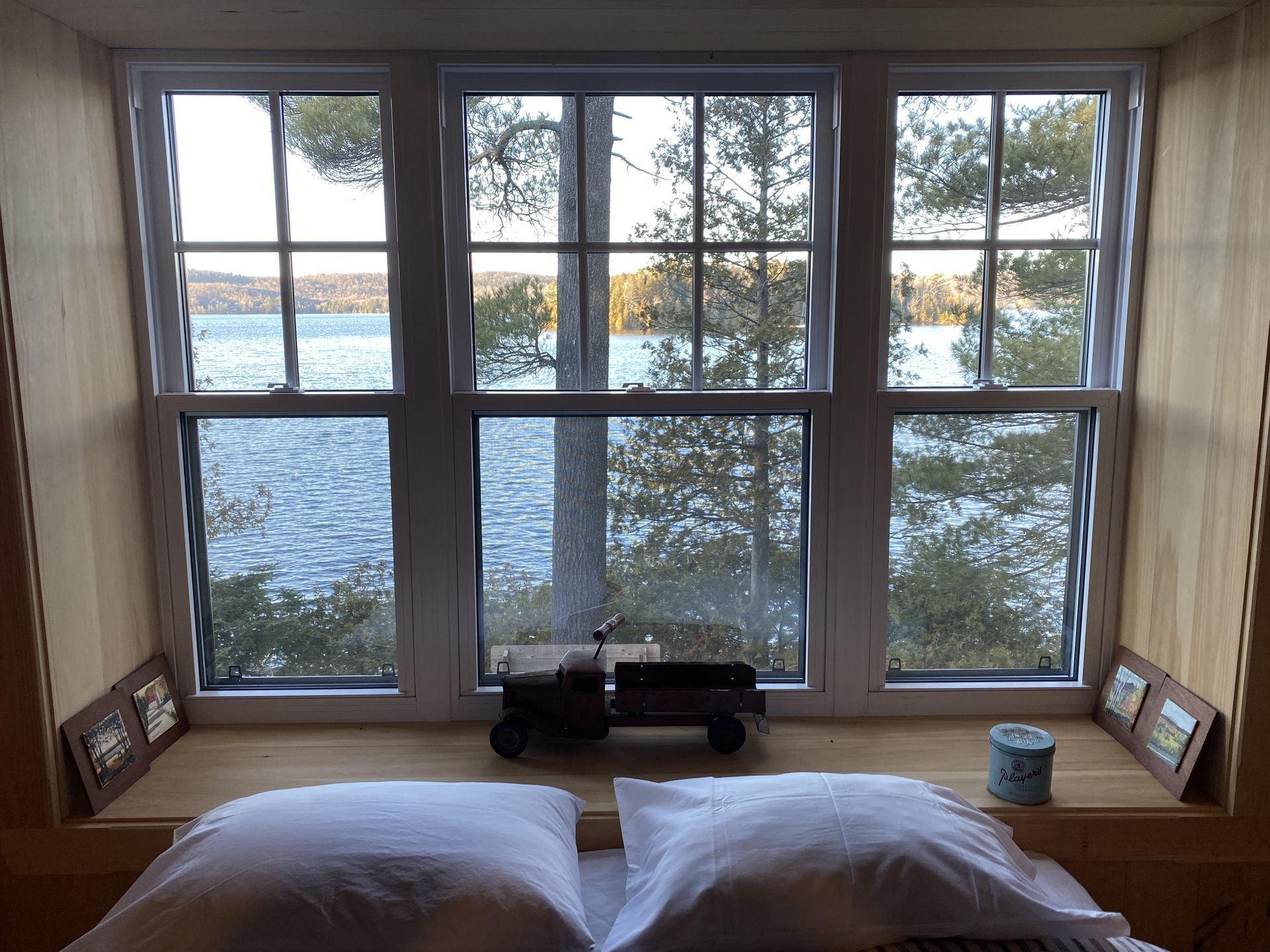 A bed in front of a window with a view of a lake