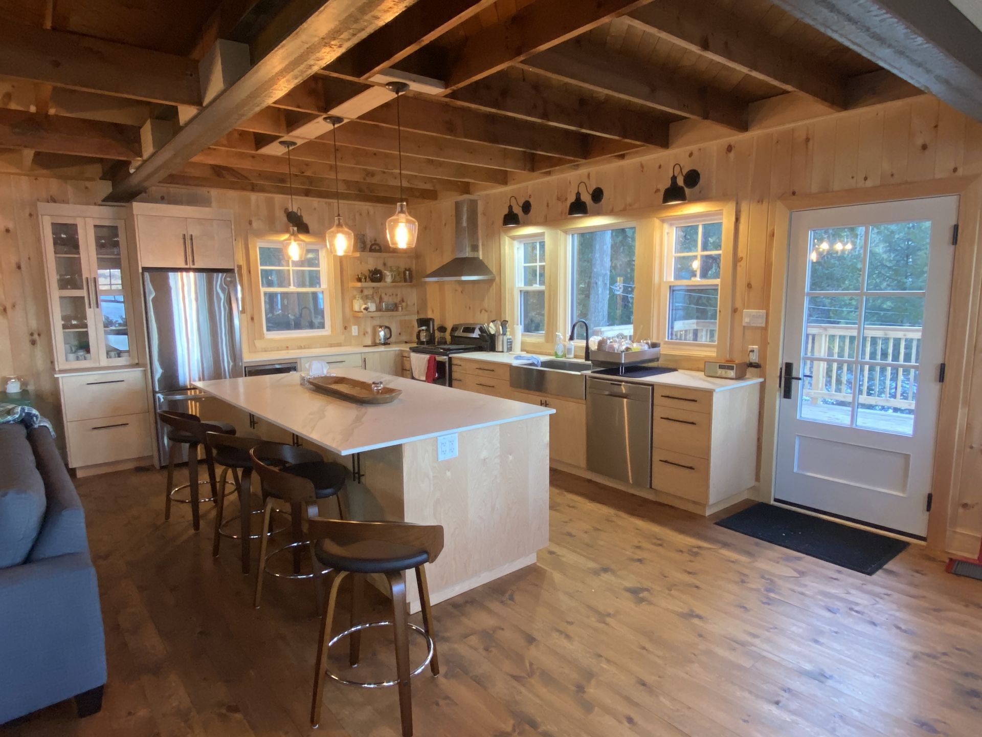A kitchen in a log cabin with stainless steel appliances and a large island.