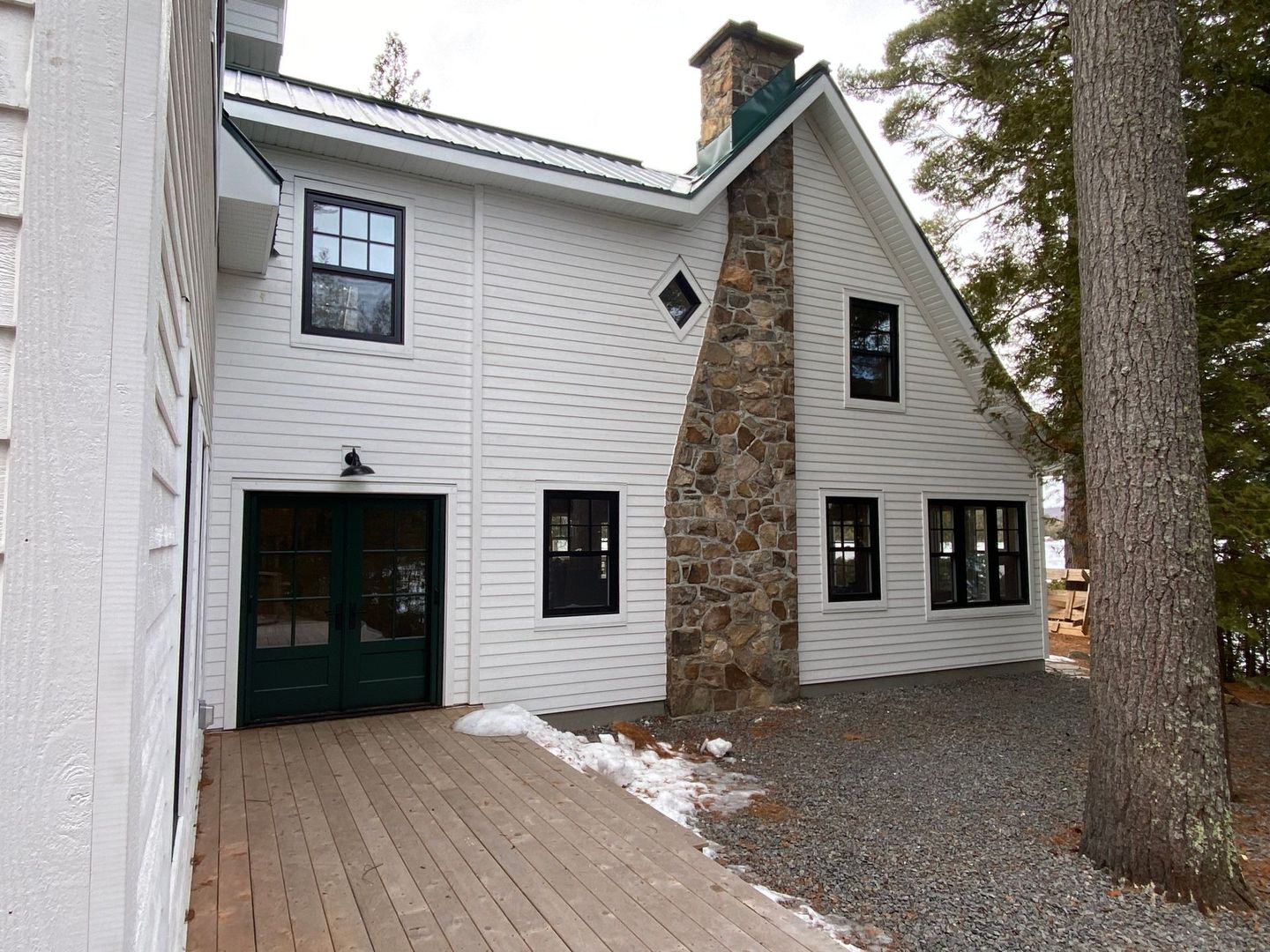 A white house with a stone chimney on the side