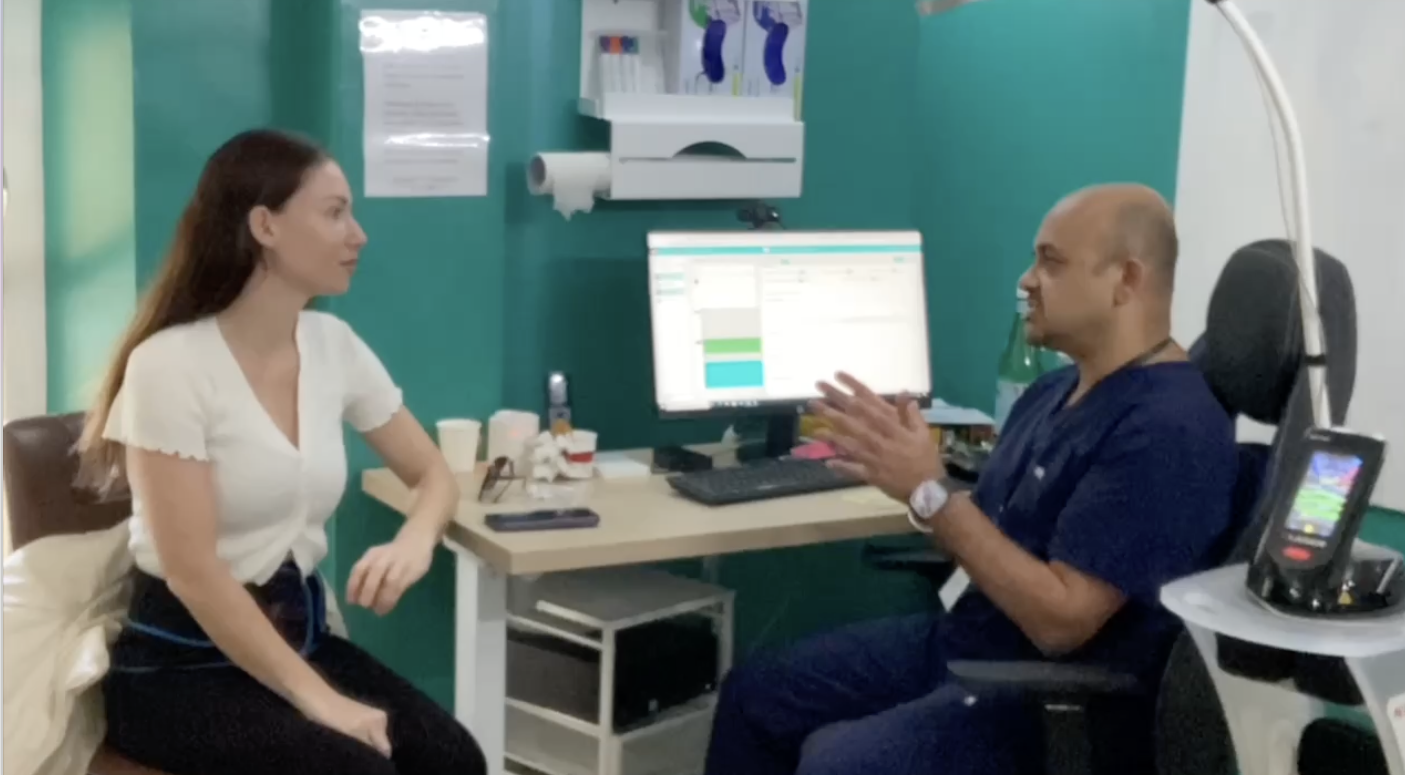 Naval Mair is talking to a patient who is sitting in front of a computer.