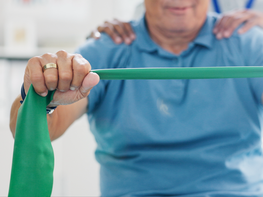 An physiotherapist examining a woman 's back on a table.