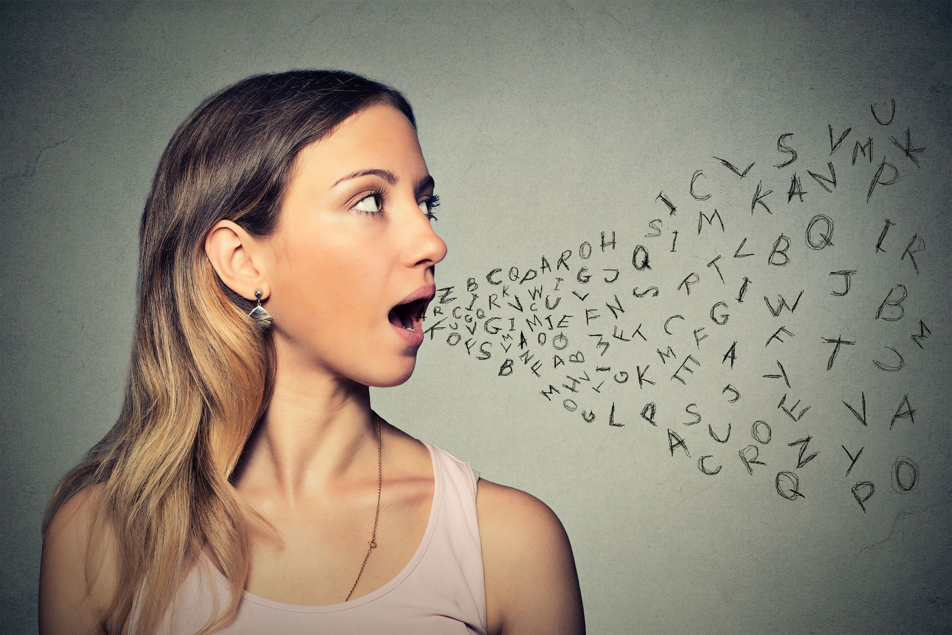 A woman is saying letters out of her mouth.