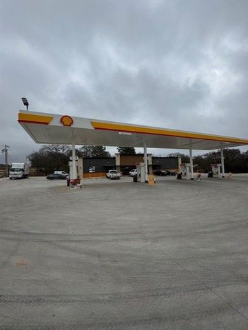 A shell gas station with a cloudy sky in the background