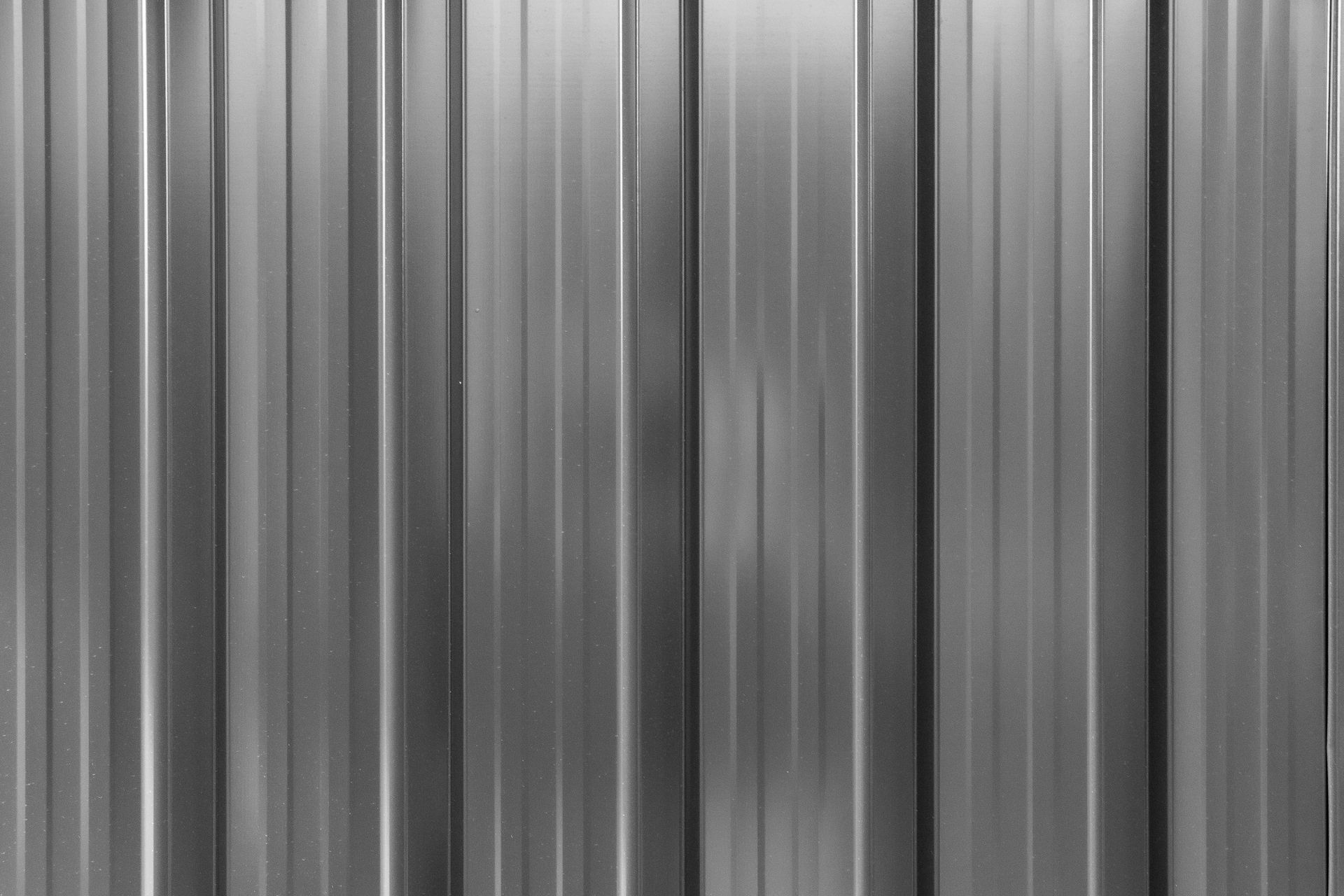 Gray corrugated metal siding with vertical lines.