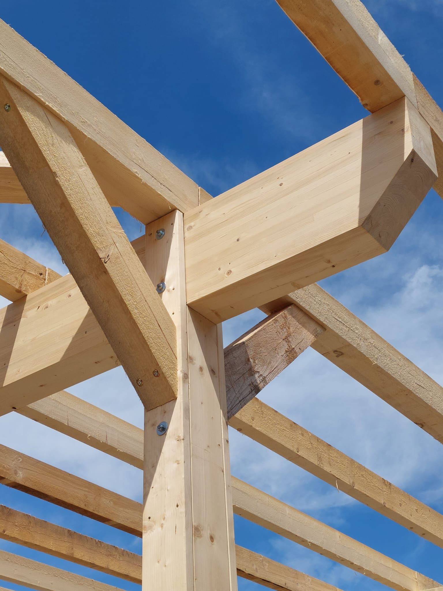Eine im Bau befindliche Holzkonstruktion mit blauem Himmel im Hintergrund
