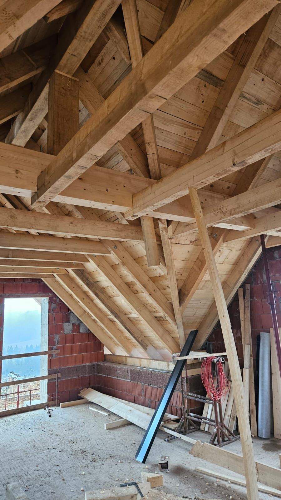 Das Dach eines Gebäudes wird mit Holzbalken gebaut.
