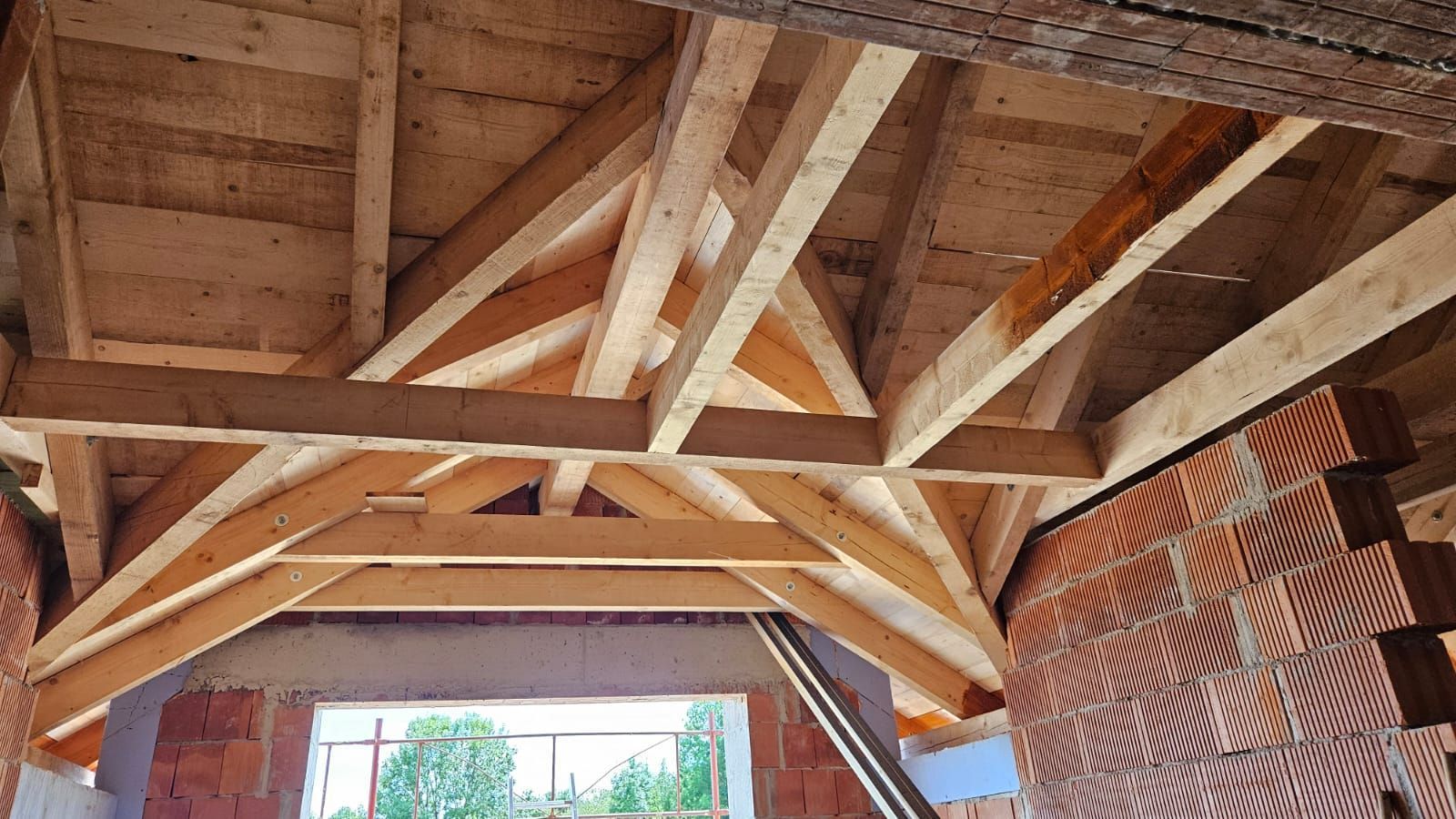 Der Dachstuhl eines Gebäudes wird mit Holzbalken gebaut.