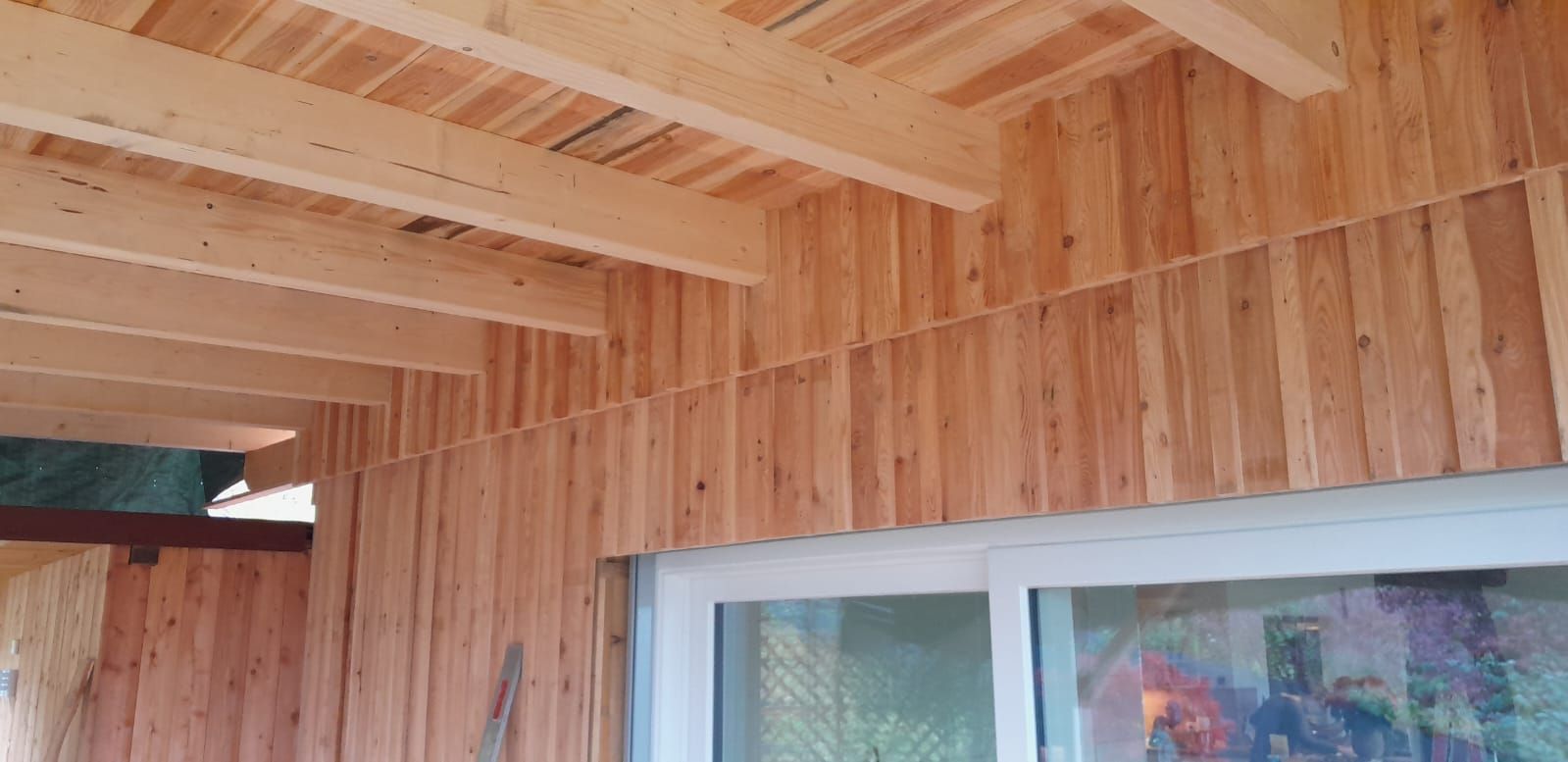 Ein Holzgebäude mit einem Fenster und einer Holzdecke.