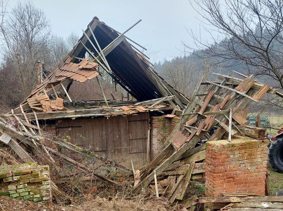 Ein altes Holzgebäude mit einem eingestürzten Dach.