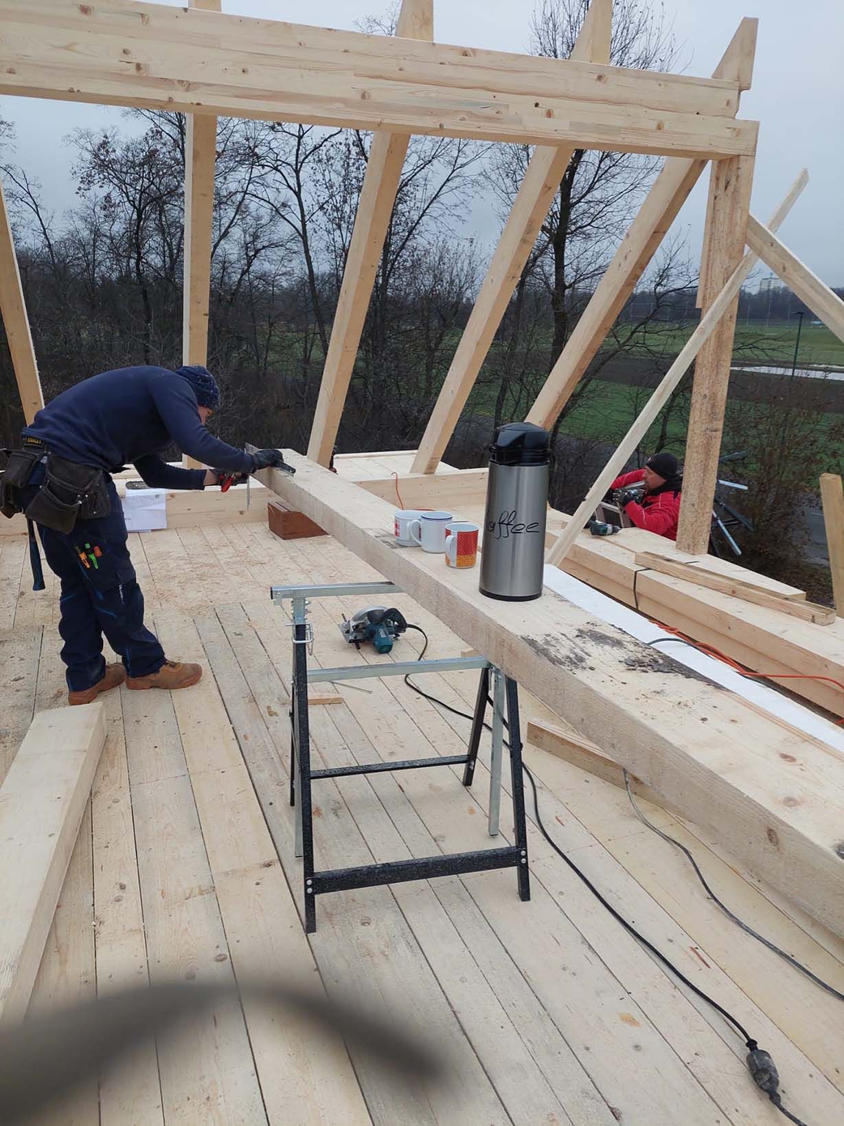 Ein Mann arbeitet an einer Holzkonstruktion.