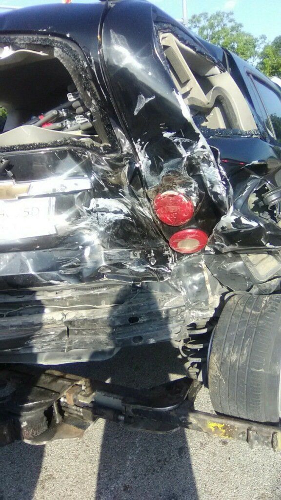 A black car that has been damaged in a car accident.