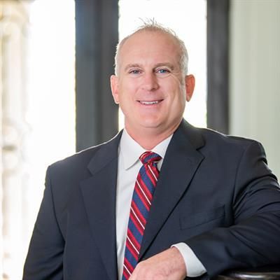 A man in a suit and tie is smiling for the camera.