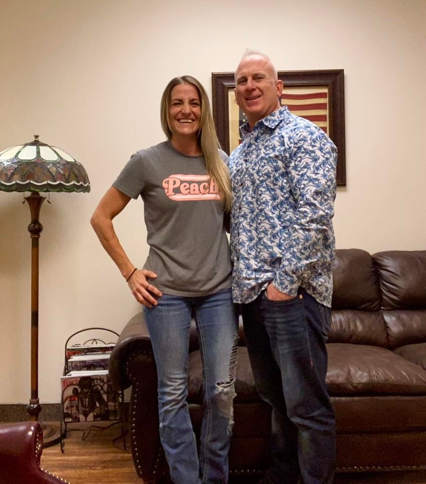 A man and a woman are posing for a picture in a living room