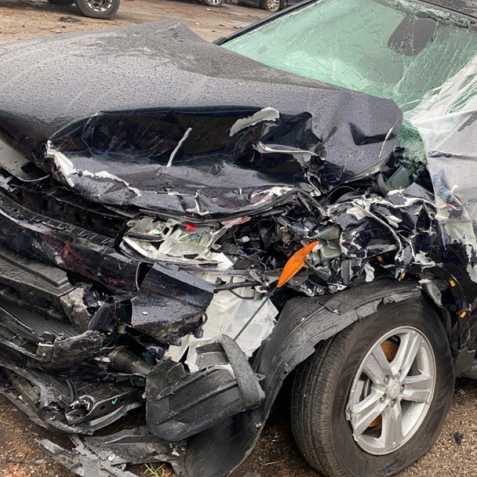 Front end of black sedan is completely crumpled from car accident in Azle