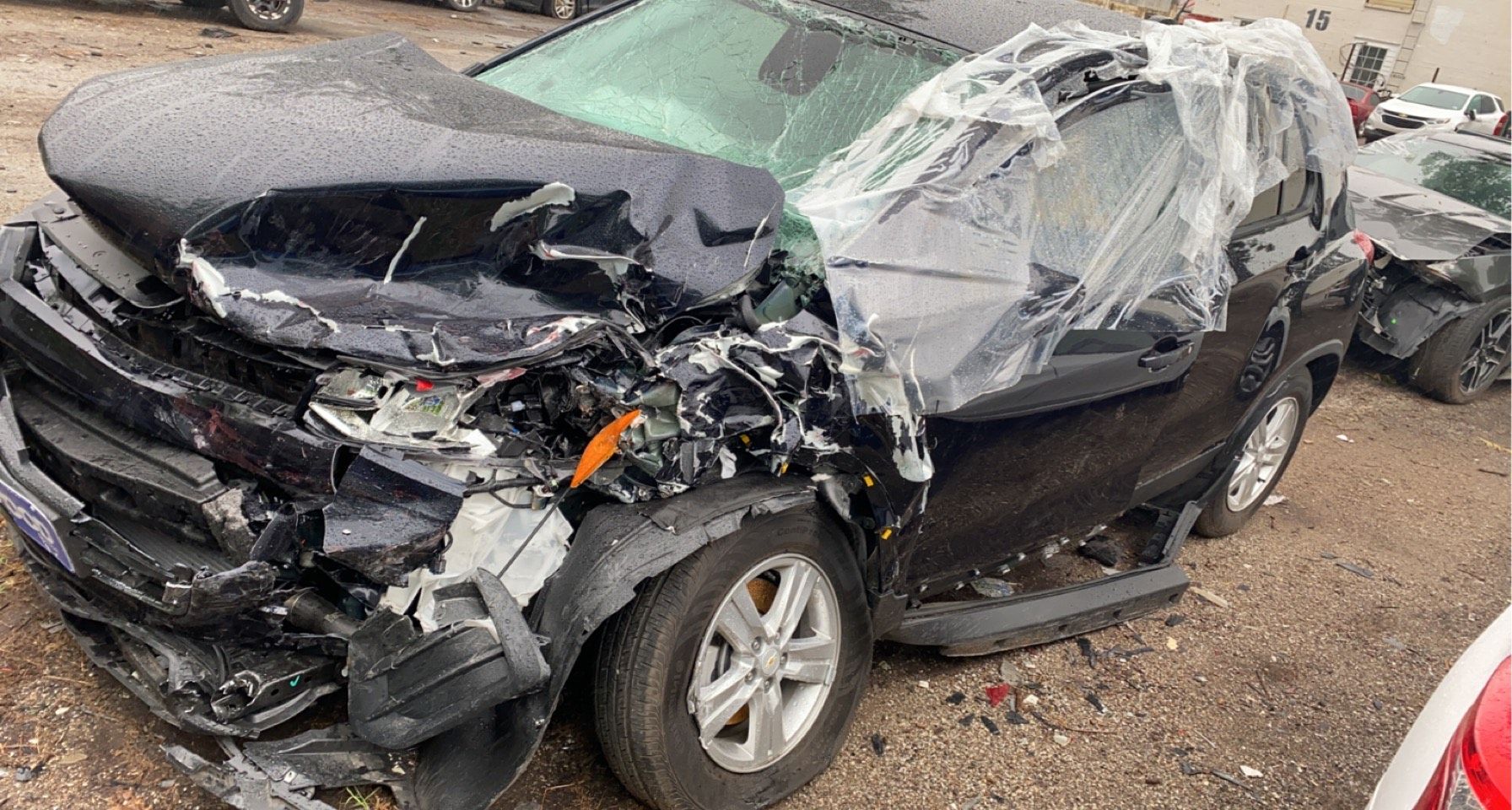 Front end of black sedan is completely crumpled from car accident in Azle