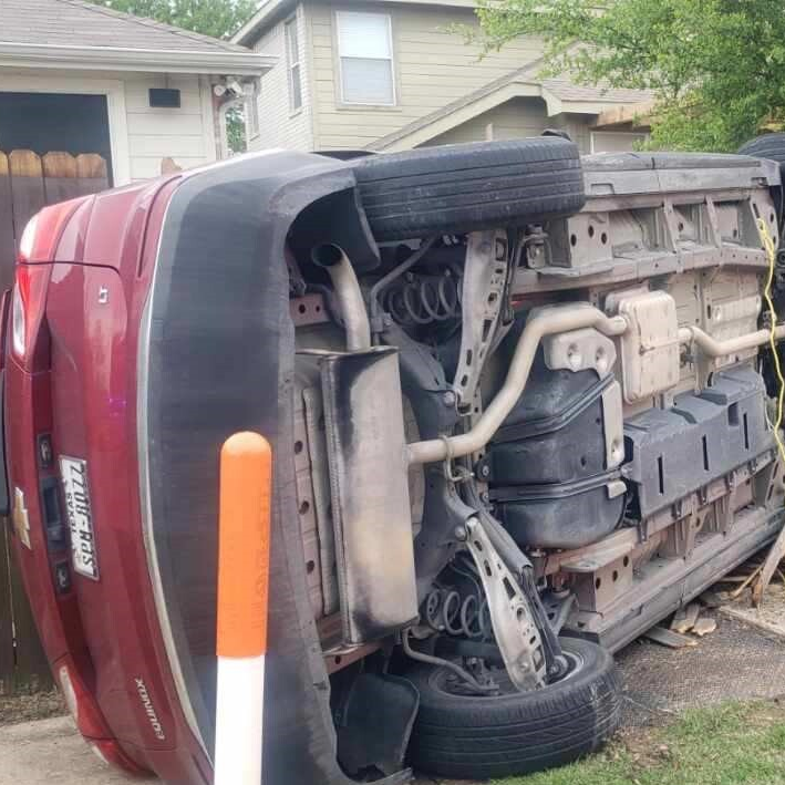 Red Chevy sedan flipped onto the passenger side due to a distracted driver