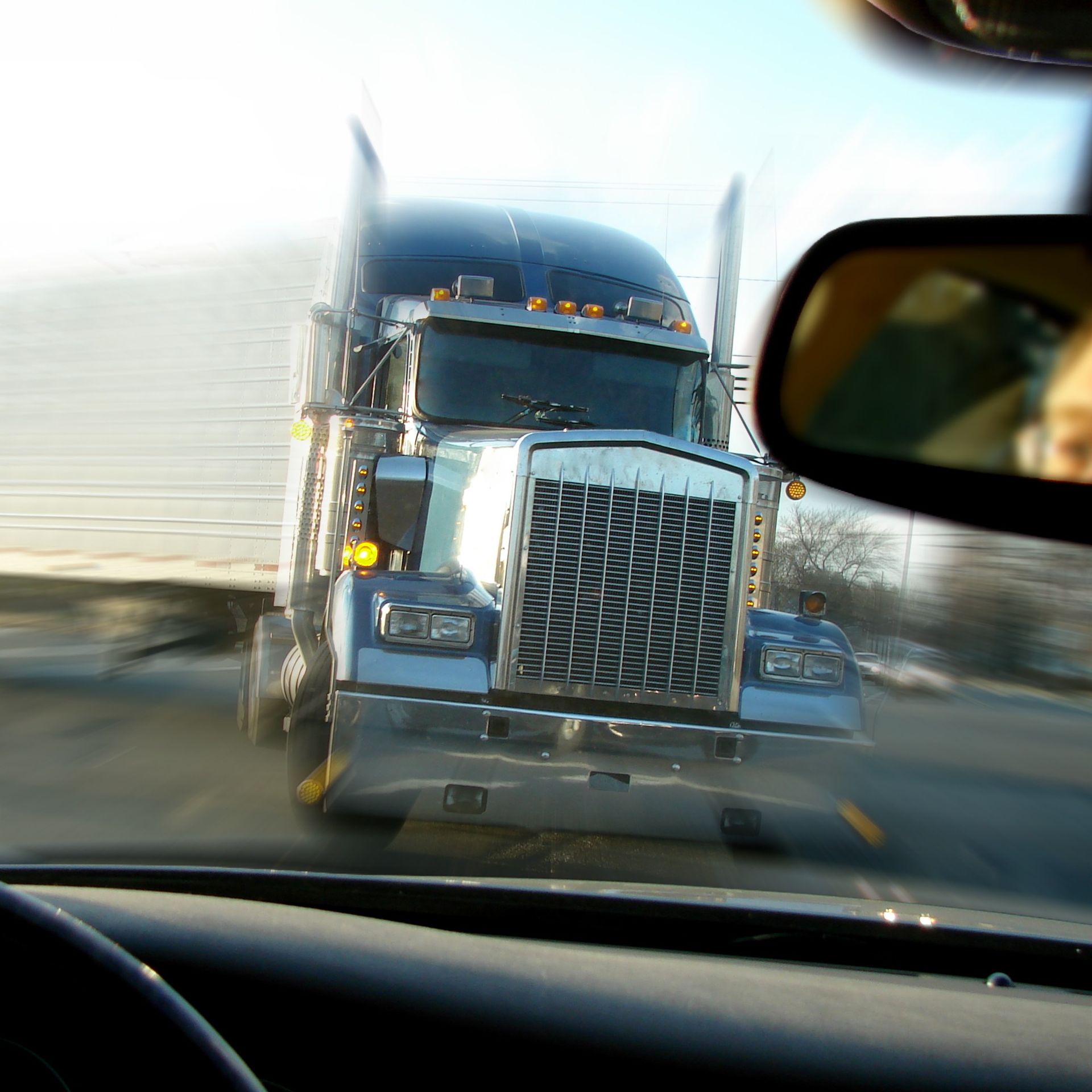 Semi-truck drives straight at a person driving a car.