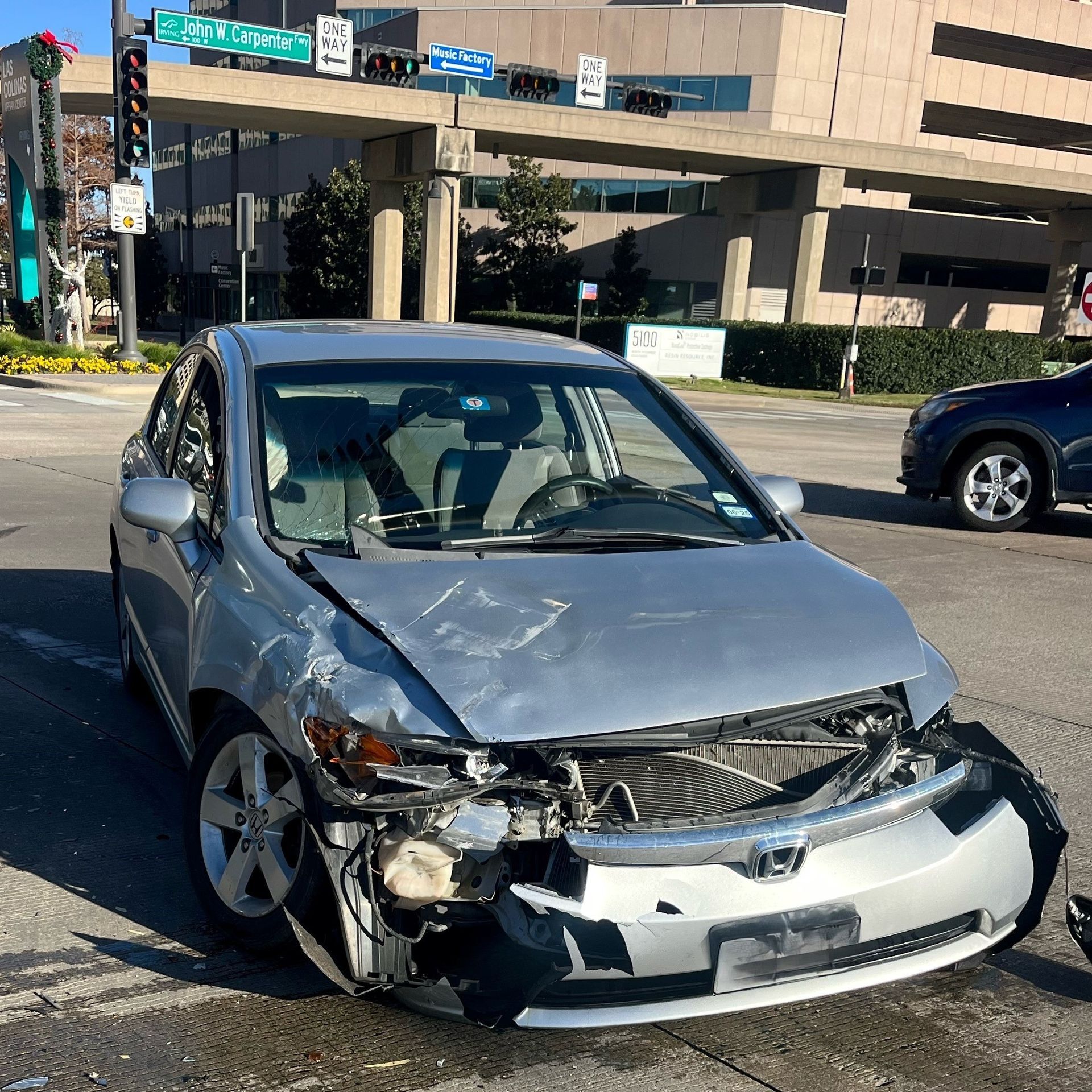 Front-passenger side of a silver sedan is smashed after a car crash in Irving.