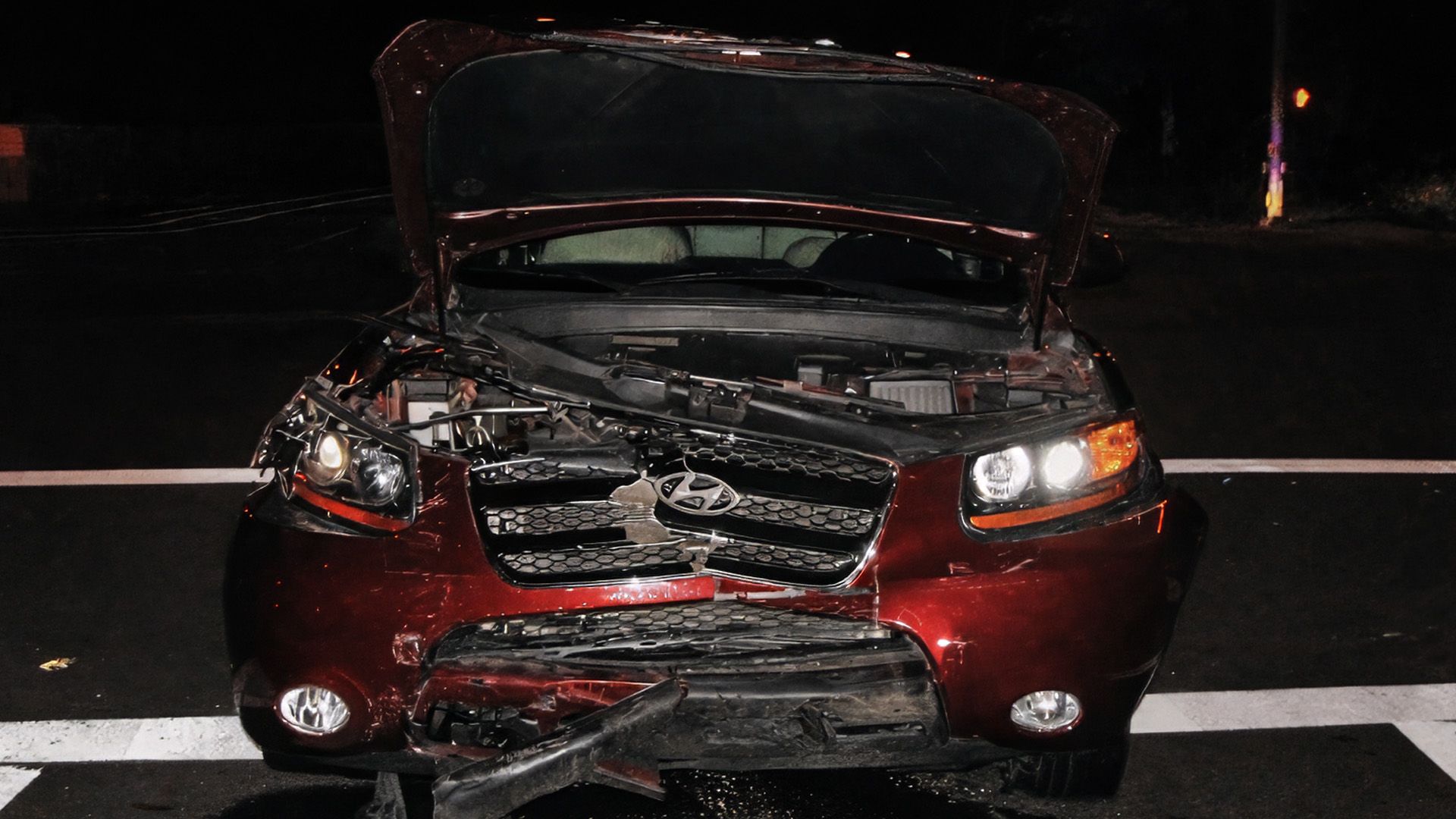 Front end of a red sedan is crushed from a speeding car accident in Dallas