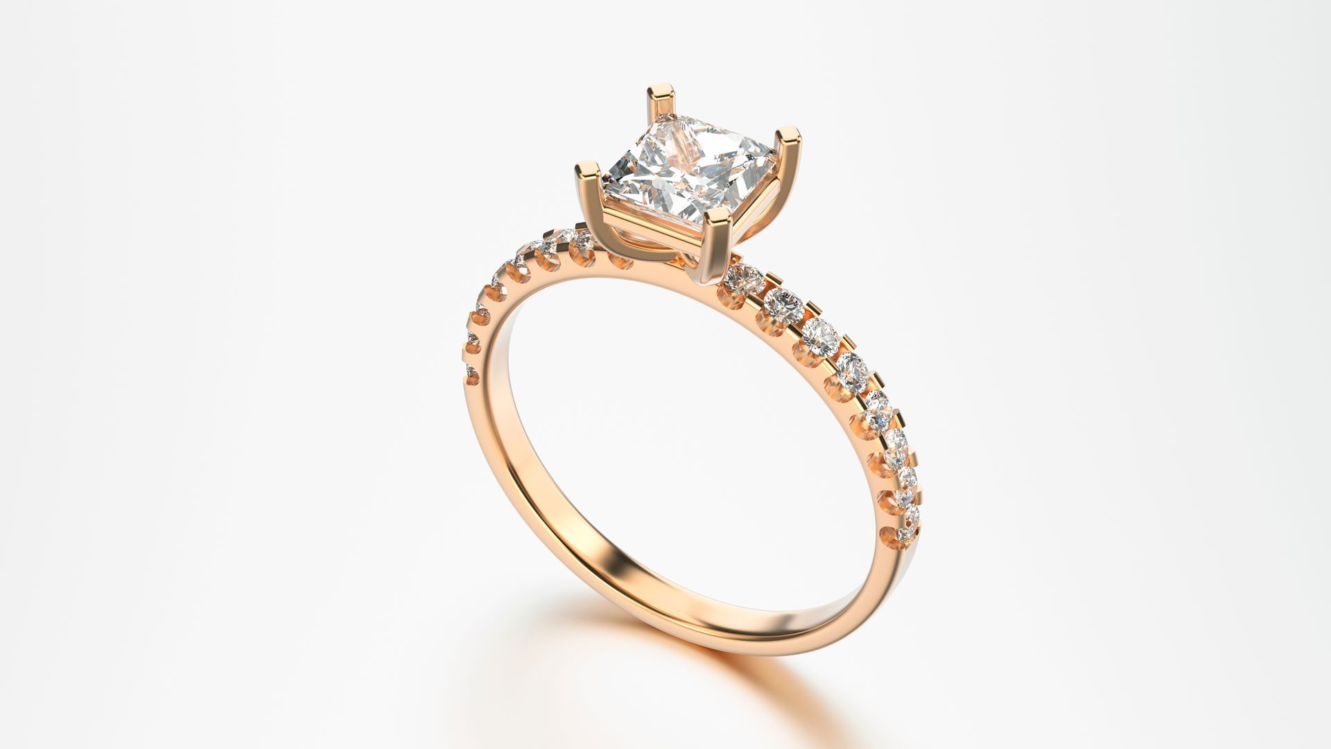 Rose gold ring with a square diamond center and smaller diamonds on the band. Rose gold ring with a square diamond center and smaller diamonds on the band.