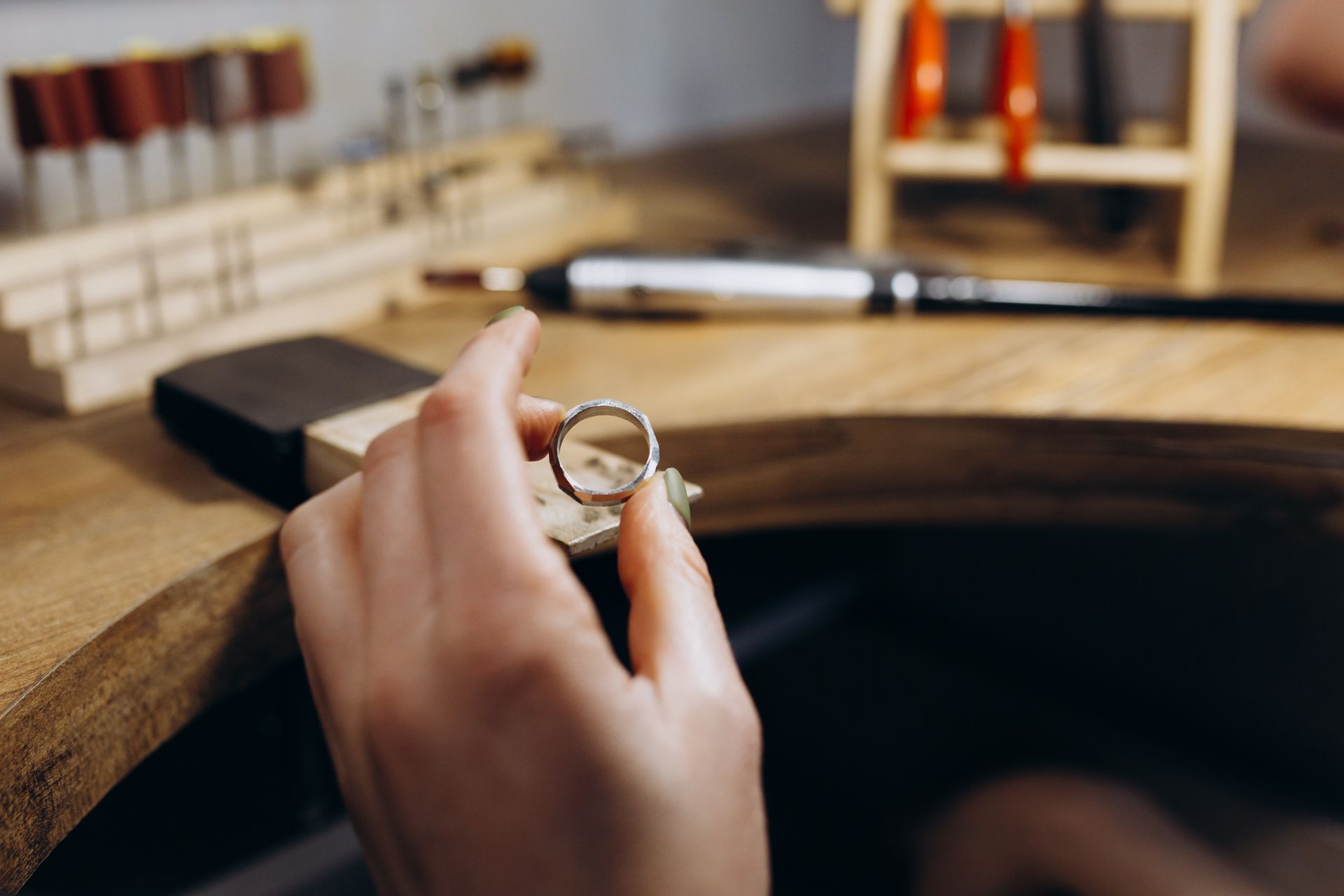 Hands inspecting a ring with a jeweler loupe during detailed professional jewelry evaluation reviews. Hands inspecting a ring with a jeweler loupe during detailed professional jewelry evaluation reviews.