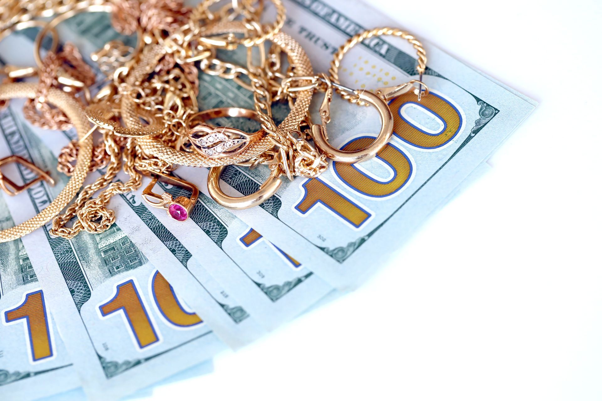Golden jewelry and dollar bills collection for a pawn shop concept and luxury asset valuation. Golden jewelry and dollar bills collection for a pawn shop concept and luxury asset valuation.