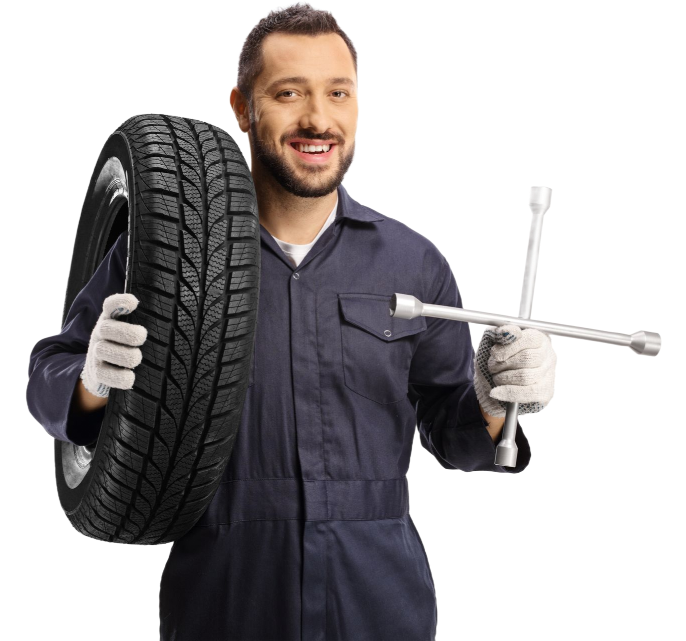 Mechanic in blue coveralls holding a tire and a lug wrench against a white background